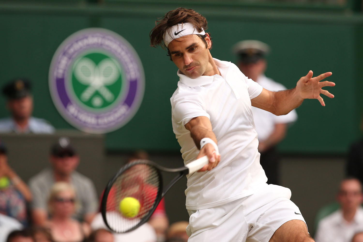 Switzerland's Roger Federer returns to Switzerland's Stanislas Wawrinka during their men's singles quarter-final match on day nine of the 2014 Wimbledon Championships at The All England Tennis Club in Wimbledon, southwest London, on July 2, 2014. AFP PHOTO / ANDREW YATES - RESTRICTED TO EDITORIAL USE (Photo credit should read ANDREW YATES/AFP/Getty Images)